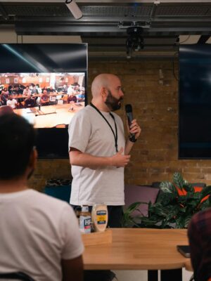 A business presentation featuring a speaker and interactive video call in an office setting.